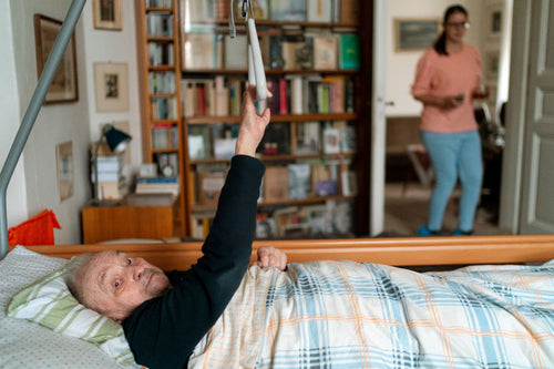 Caregiver supporting senior getting out of bed safely